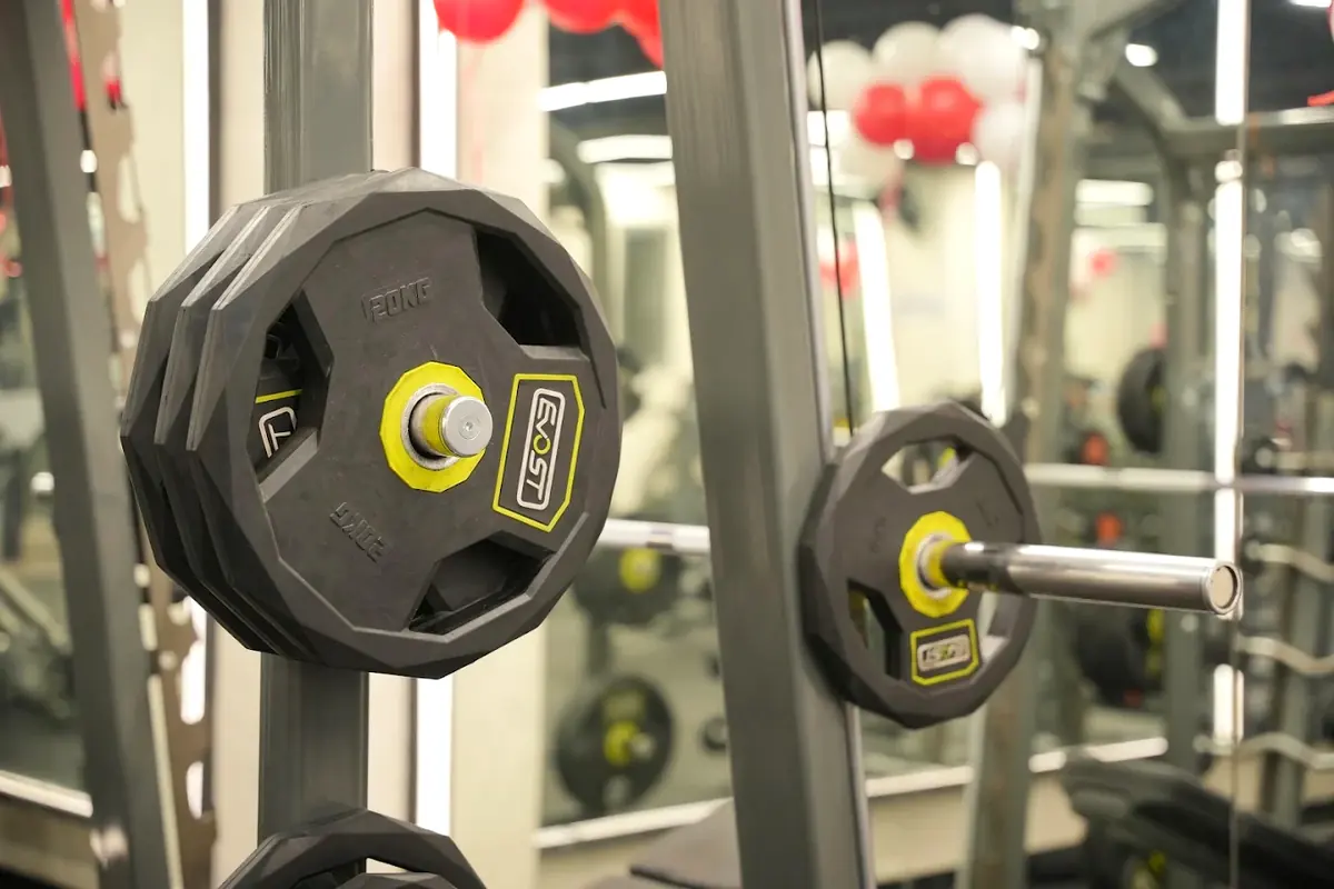 Twenty kilo Olympic plates loaded on a barbell in the Smith machine