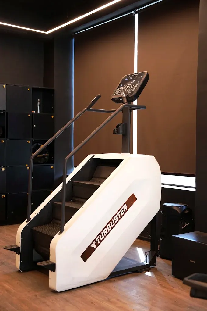 A stair climber machine standing beside a wall of numbered lockers
